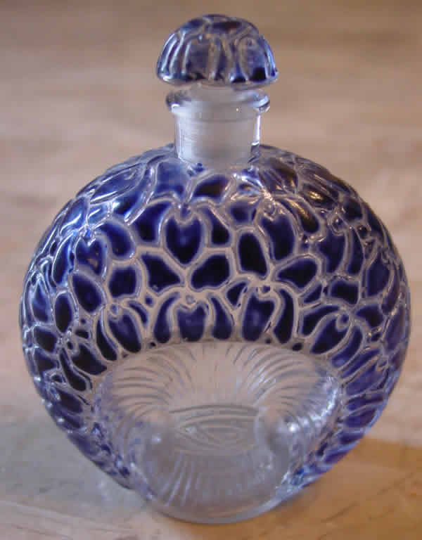 Флакон аромата La Violette («Фиалки»): 1925 г., 3,35 дюйма, прозрачное стекло, синяя эмаль. Флакон продан с аукциона в Омахе в 2012 г. (Небраска, США) за $ 1625